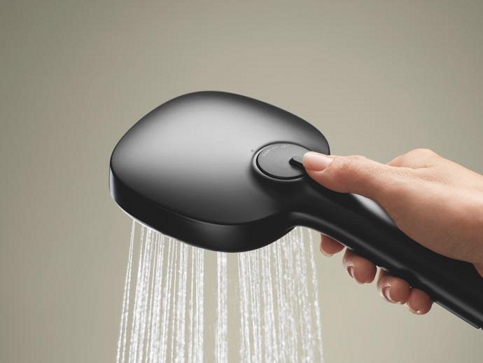 A hand holding Grohe Matte black cube hand shower back