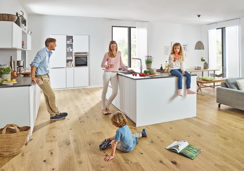 Gezin met kinderen die zich in een keuken met een GROHE Blue Home bevinden