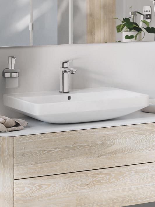 Крупный план раковины GROHE Euro Ceramic с сочетающимся хромированным смесителем и аксессуарами.