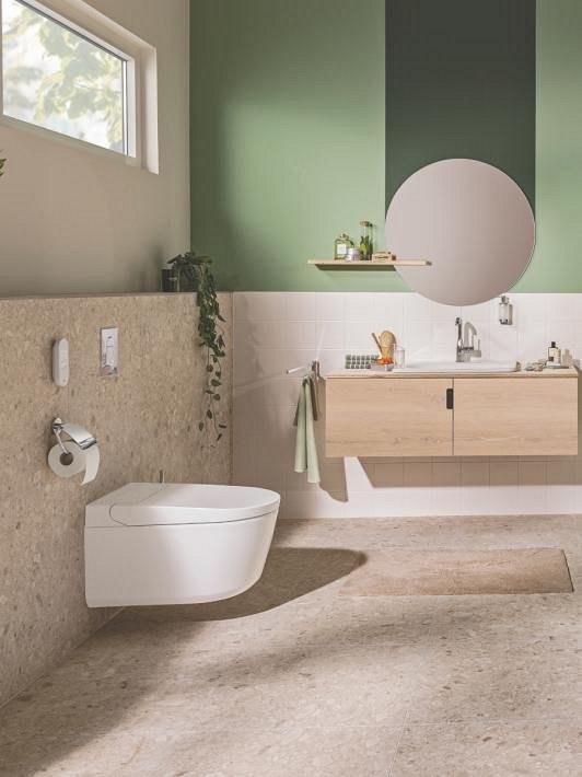 A Grohe Sensia Shower toilet in a beige and green bathroom 