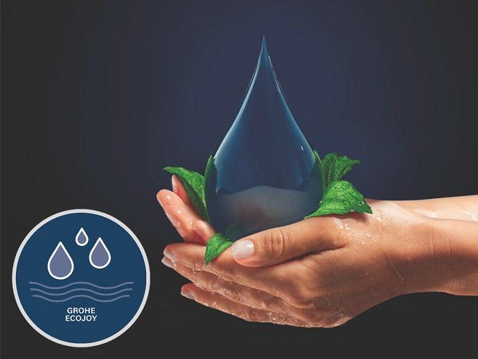 Hands holding a large water droplet surrounded by green leaves, with the GROHE EcoJoy logo in the corner