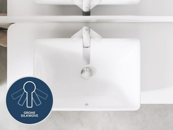 Vedere de sus a unei chiuvete dreptunghiulare albe moderne, cu o baterie cromată GROHE, cu logo-ul Grohe SilkMove în colț