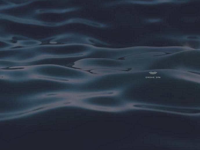Close-up of dark, gently rippling water, creating a serene and reflective surface with the words "GROHE SPA" included.