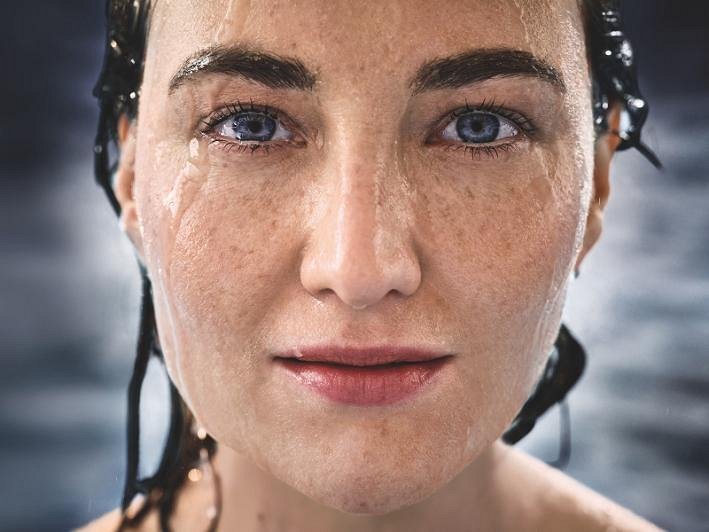 Modernes Bad mit GROHE Produkten, mit begehbarer Dusche, wandmontiertem WC und stilvollem Waschbecken in einem eleganten erdigen Farbton.