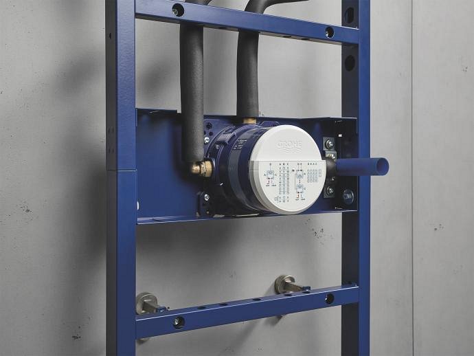  A close-up of a GROHE Rapido Shower Frame mounted on a wall, showcasing the blue support structure and attached plumbing components.