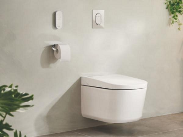 A GROHE Sensia shower toilet in a beige and grey-decorated bathroom with wooden cabinets.