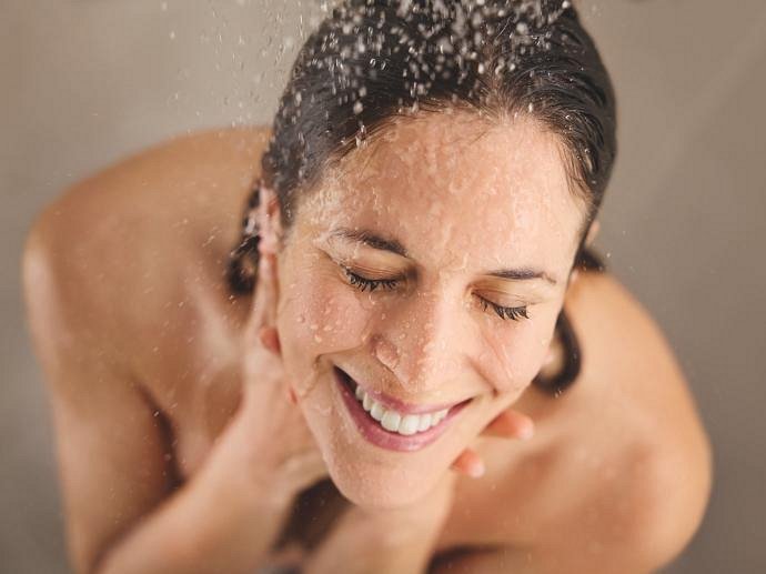 Een lachende vrouw onder de douche 