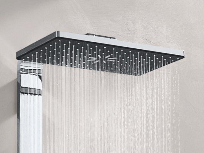 Water flowing out of the Rainshower Aqua Pure shower system mounted on a light gray wall, featuring the rectangular shower head design.