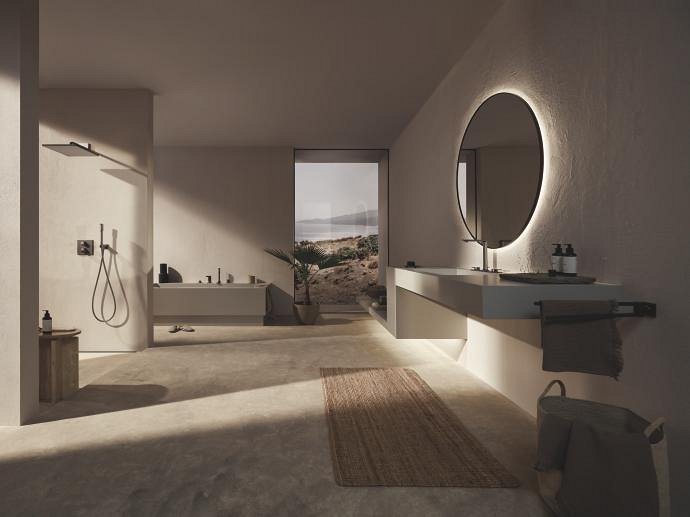 Dimly lit bathroom with dark grey fittings, refined satin graphite GROHE fittings and soft, warm beige lighting.