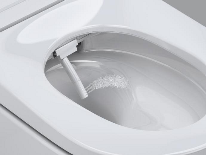 Un'immagine ravvicinata di un WC con funzione bidet GROHE Sensia, che mostra il getto orientabile in uso.