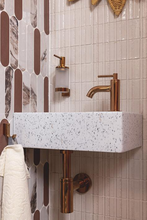 Close-up van de wasbak met GROHE toiletkraan in Warm Sunset en bronzen accessoires