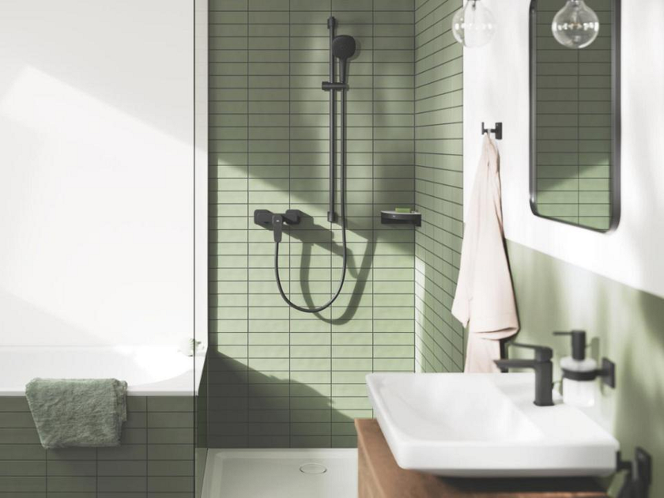 Mat zwarte opbouw douche in badkamer met groene tegels