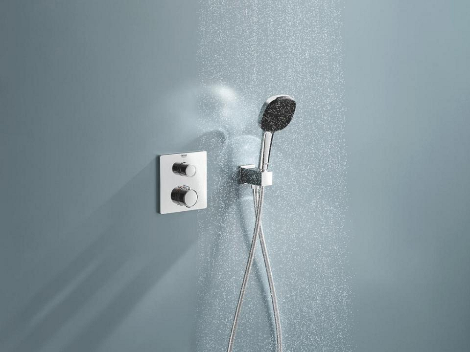 Een bad met een matzwarte thermostaatkraan en ronde handdouche