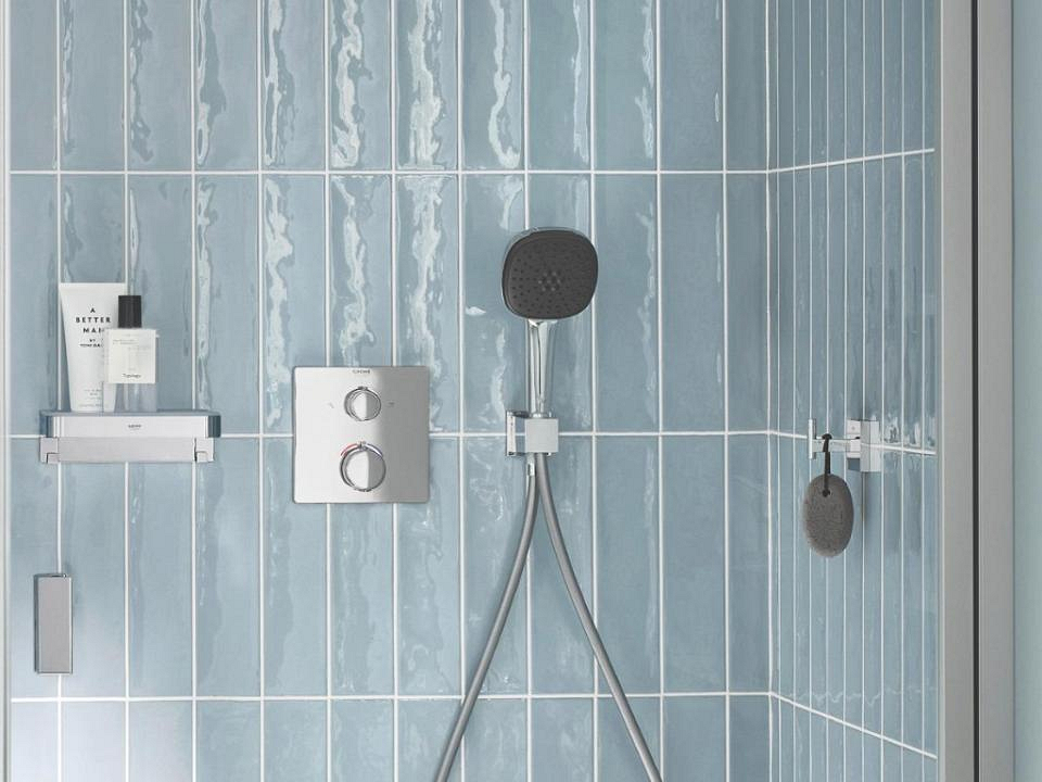Waterbesparende douche in badkamer met lichtblauwe tegels